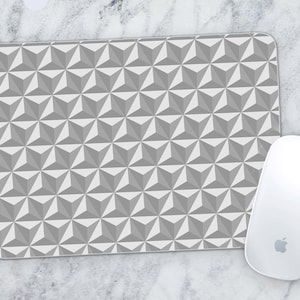 May include: A grey and white geometric patterned mouse mat. The pattern is made up of repeating triangles.