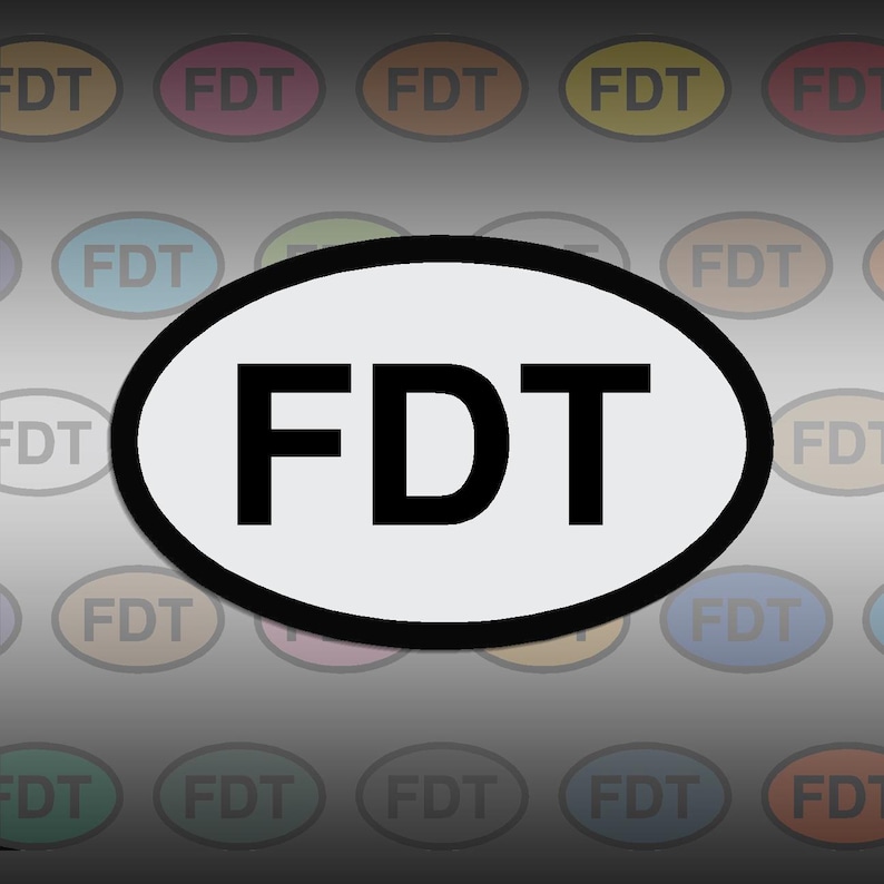 May include: White oval sticker with black text that reads "FDT". The sticker is surrounded by a black border. The background is a blurred image of many colorful oval stickers with the same text.