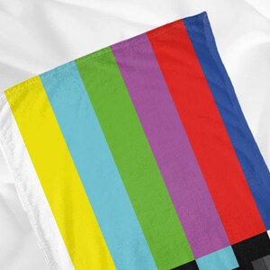 Puede incluir: Una tela de rayas coloridas con un dise&ntilde;o de patr&oacute;n de prueba de televisi&oacute;n. La tela presenta rayas alternas de amarillo, azul claro, verde, morado, rojo y azul.