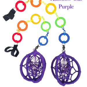 May include: Two dream catchers with a rainbow-colored chain of rings. The rings transition from red to orange, yellow, green, and blue. The dream catchers are purple with a webbed design. The text "Rainbow into Purple" is in the upper right corner.