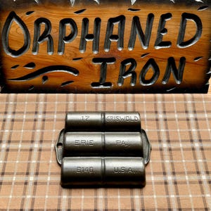 May include: A cast iron muffin tin with three sections. The tin is labeled "Griswold" and "Erie, Pa. U.S.A."