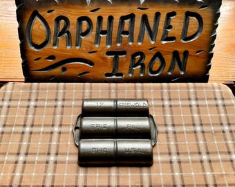 May include: A cast iron muffin tin with three sections. The tin is labelled "Griswold" and "Erie, Pa. U.S.A."