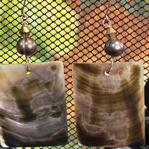 Op de afbeelding: Een set van drie keramische mokken met een gespikkelde, matte afwerking. De mokken zijn in de kleuren cr&egrave;me, lichtbruin en donkerbruin. Elke mok heeft een eenvoudig, minimalistisch ontwerp en een afgeronde handgreep.