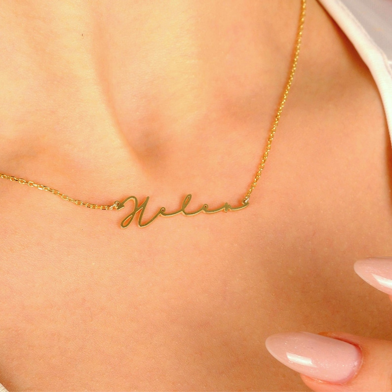 Pu&ograve; includere: Una collana d'oro con il nome "Helen" scritto in corsivo.