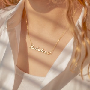 May include: A gold necklace with the word "Fabulous" spelled out in cursive script.