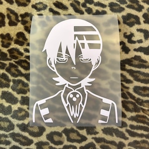May include: White vinyl sticker of a character from the anime Soul Eater. The character has white hair with a black stripe, black eyes, and is wearing a black suit with a white collar and a black tie with a skull design.