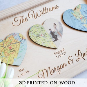 May include: A wooden plaque with three heart-shaped pieces, each with a map and a date. The top heart has a map of Manila, Philippines, with the date "Married 9/18/18". The middle heart has a photo of a couple, with the date "Engaged 1/16/17". The bottom heart has a map of Staten Island, New York, with the date "Met 1/16/16". The plaque also has the text "The Williams Morgan & Linda 3D PRINTED ON WOOD".