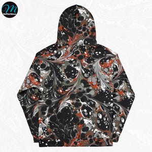 May include: Black hoodie with a red, white, and gray marbled pattern. The hoodie has a drawstring hood and a kangaroo pocket.