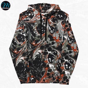 May include: A black hoodie with a red, white, and gray marbled pattern. The hoodie has a drawstring hood and a kangaroo pocket.