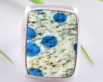 May include: A silver ring with a rectangular blue and white gemstone. The gemstone has a speckled pattern with blue spots.