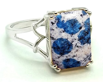May include: A silver ring with a blue and white azurite gemstone set in a gold bezel. The ring has a delicate, openwork design.
