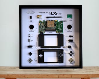 Oprawiona w czarną ramę grafika demontowana z Nintendo DS Lite: retro konsola do gier