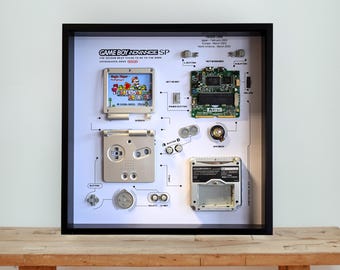 Oprawiona srebrna grafika demontowana na GameBoy Advance SP: retro konsola do gier