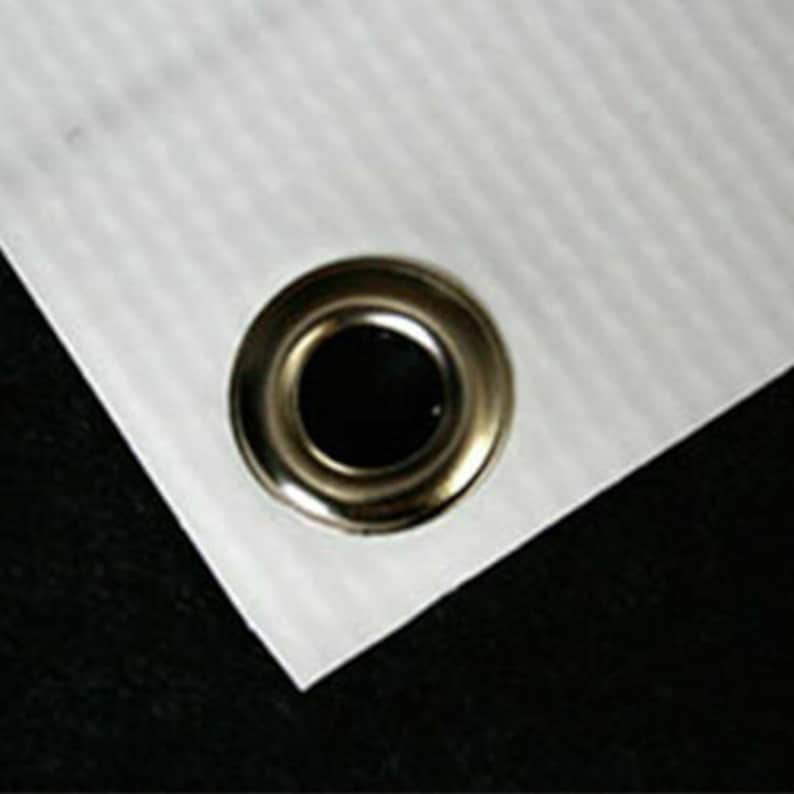 May include: Close-up of a white banner with a silver grommet.