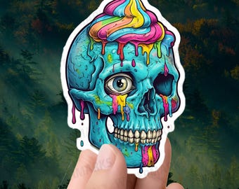 May include: A blue skull with a rainbow swirl on top, dripping with colorful paint. The skull has one eye visible, and the paint is dripping down the sides of the skull.