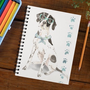 May include: A white and black spotted dog wearing green glasses and a blue bandana sits on a white background with blue paw prints. The dog is looking to the left.