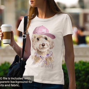 May include: A white t-shirt with a watercolor illustration of a dog wearing a pink baseball cap with the text "Best Buddy" printed on the front.
