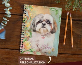 May include: A spiral-bound notebook featuring a watercolor-style illustration of a Shih Tzu dog with a heart-shaped collar tag. The cover displays the name Cleo in cursive script, surrounded by soft-toned floral accents in yellow and pink.