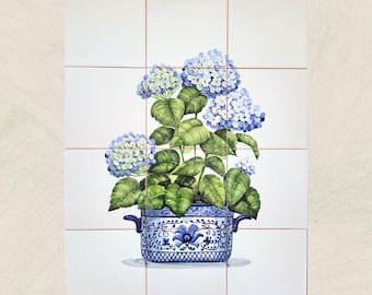 Puede incluir: Azulejo de cerámica pintado a mano con una maceta azul y blanca llena de flores de hortensia azules y hojas verdes. La maceta tiene un diseño decorativo. El azulejo está sobre un fondo blanco con líneas de cuadrícula rojas.
