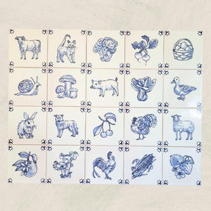 May include: A set of 20 white ceramic tiles with blue illustrations of farm animals, vegetables, and fruits. Each tile features a different design, including a cow, cat, broccoli, radishes, eggs, snail, mushroom, pig, duck, rabbit, dog, cherries, turkey, sheep, and more.