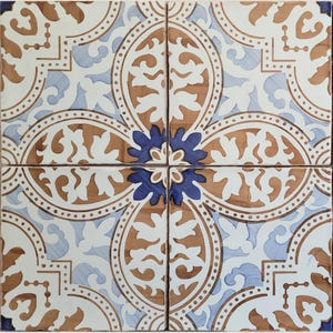 Pode incluir: Um conjunto de quatro azulejos de cerâmica quadrados dispostos em grelha, apresentando um padrão repetitivo de motivos florais em branco, azul claro e castanho. Um elemento em forma de estrela azul escuro está centrado na interseção.