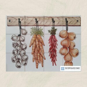 May include: A set of four white ceramic tiles with a painted image of garlic, carrots, chili peppers, and onions hanging from a wooden rack. The tiles are part of a kitchen backsplash.