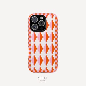 May include: A phone case with a geometric diamond pattern in orange, pink, and white. The case has a pink and orange checkered border. The phone case has a camera module with three lenses. The brand name "MIREI DESIGN" is printed at the bottom.