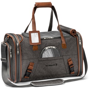 May include: Gray pet carrier with brown leather accents and a mesh window. The carrier has a top handle, a shoulder strap, and a zippered pocket on the front. The text "Mr. Peanut's" is embroidered on the front of the carrier.
