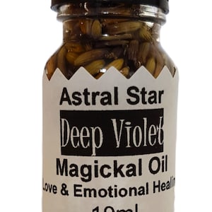 Puede incluir: Una pequeña botella de vidrio con tapa negra, llena de un líquido transparente y materia vegetal. La etiqueta dice "Astral Star Deep Violet Magickal Oil Love & Emotional Healing 10ml."