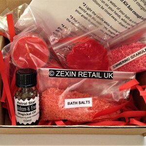 May include: A cardboard box filled with red bath products, including bath salts, simmering granules, candles, and a bottle of oil. The box is labelled "Zexin Retail UK".