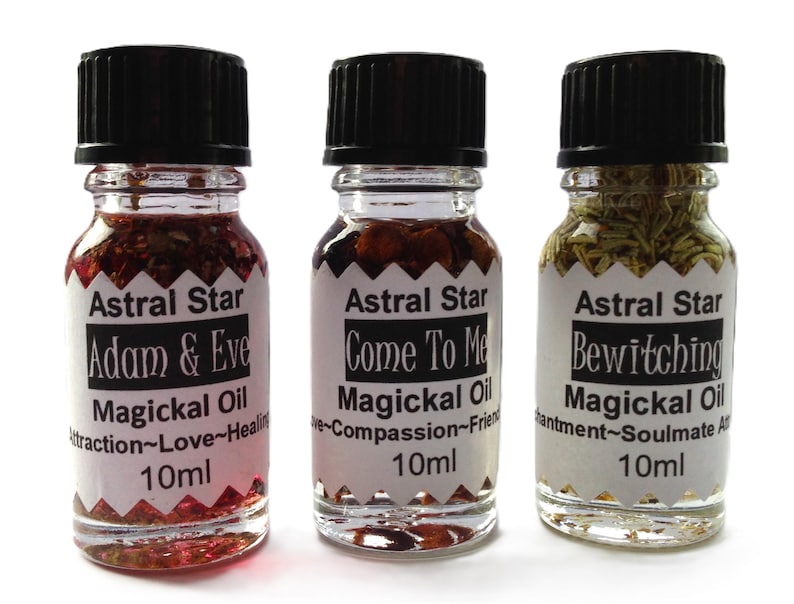 May include: Three small glass bottles with black caps and labels. Each bottle contains a clear liquid with herbs and flowers. The labels read "Astral Star Adam & Eve Magickal Oil Attraction~Love~Healing 10ml", "Astral Star Come To Me Magickal Oil Love~Compassion~Friendship 10ml", and "Astral Star Bewitching Magickal Oil Enchantment~Soulmate Attraction 10ml".