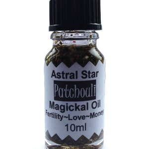 May include: A small glass bottle with a black cap filled with a dark liquid and herbs. The label reads "Astral Star Patchouli Magickal Oil Fertility~Love~Money 10ml".