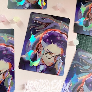 Peut inclure: Impression artistique holographique représentant une illustration stylisée d'une personne avec des lunettes et un serpent. L'œuvre d'art présente un schéma de couleurs violet et bleu avec des accents irisés. Le texte "MOONTER SKY" est présent.