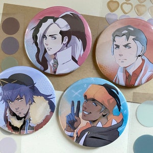 Könnte beinhalten: Vier runde Anstecknadeln mit Anime-Charakteren. Die Nadeln sind bunt und zeigen verschiedene Charaktere mit einzigartigen Frisuren und Kleidung.