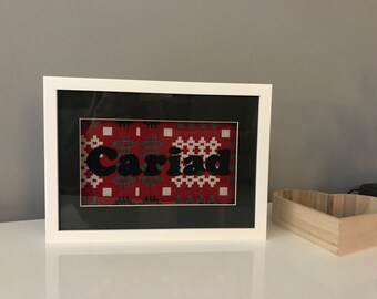 Cariad with red Welsh tapestry fabric in a white frame