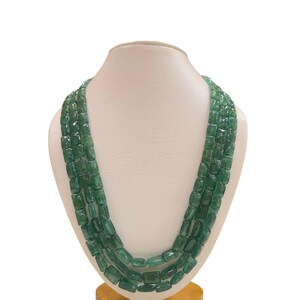May include: A green gemstone necklace with multiple strands of rectangular beads.