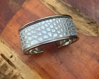 vari disegni in finta pelle su bracciale borsale argenteo