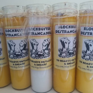 May include: Four yellow candles with black and white labels that read "Blockbuster Destrancadera" and "To Remove Obstacles & Enemies" with a graphic of two hands breaking free from chains.