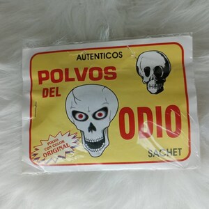 May include: A yellow and white package with a skull graphic and the text "AUTENTICOS POLVOS DEL ODIO SACHET". The text "POLVO CON COLOR ORIGINAL" is also visible on the package.