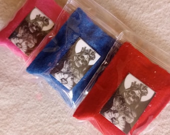 May include: Three small pouches made of felt in pink, blue, and red. Each pouch has a clear plastic window showing a black and white image of a woman with a crown and flowers.