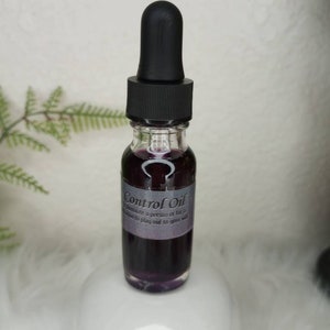 May include: A small glass bottle with a black dropper top filled with a dark purple liquid. The bottle has a white label with the text "Control Oil" and a description about how to use the oil.