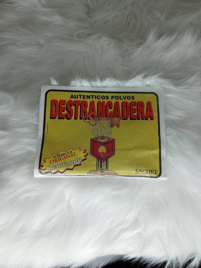May include: A yellow and white packet of "AUTENTICOS POLVOS DESTRANCADERA"  powder. The packet has a picture of a key and a lock with the text "FORMULA ORIGINAL REFORZADA" and "SACHET".