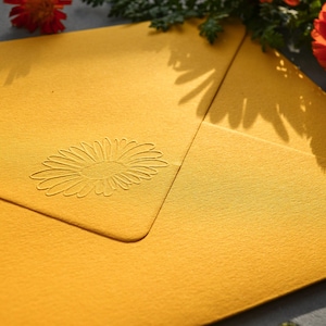Briefumschlag gelb mit eingeprägter Blume