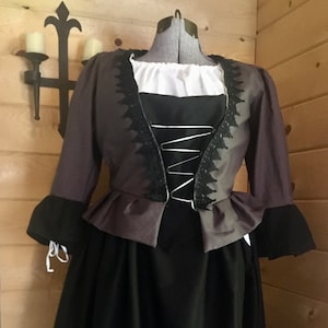May include: A black and purple dress with a lace trim and a white undershirt. The dress has a fitted bodice and a full skirt.
