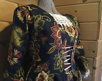 May include: A long-sleeved, dark blue jacket with a floral print in shades of red, gold, and green. The jacket has a fitted bodice and a flowing skirt. The fabric is a satin-like material.
