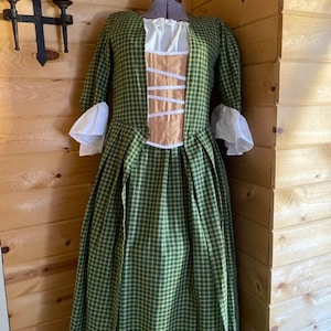 May include: A green and white plaid dress with a white lace trim and a matching white lace bodice. The dress has a fitted bodice and a full skirt.