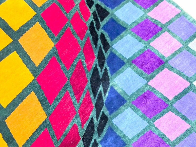 Puede incluir: Primer plano de un patr&oacute;n geom&eacute;trico colorido. El dise&ntilde;o presenta filas de rombos en amarillo, naranja, rosa, morado, azul y negro, delineados en verde oscuro. El patr&oacute;n es vibrante y llamativo.