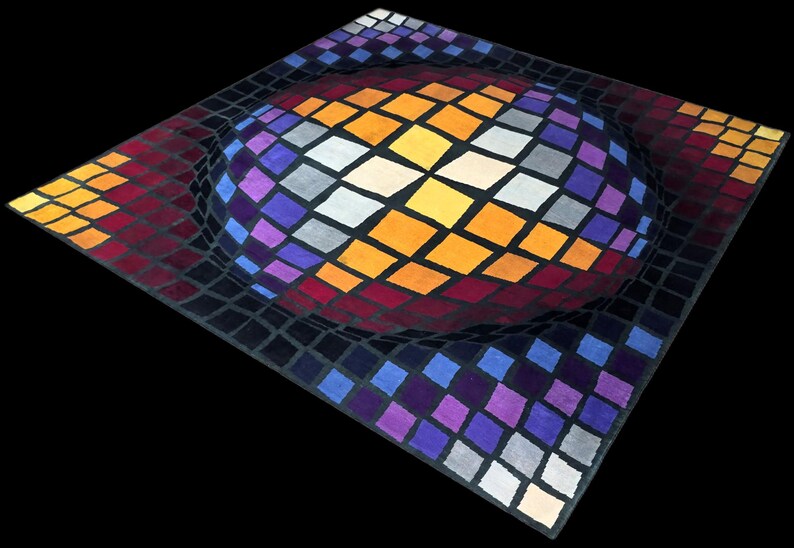 Puede incluir: Una alfombra cuadrada con un dise&ntilde;o tridimensional. La alfombra presenta una forma esf&eacute;rica central compuesta por rombos de colores en tonos naranja, morado y blanco. El &aacute;rea circundante tiene un patr&oacute;n de cuadr&iacute;cula.