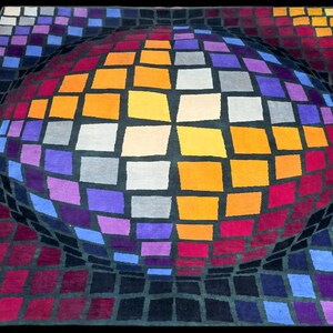 Puede incluir: Una vibrante alfombra geom&eacute;trica con un dise&ntilde;o esf&eacute;rico en 3D. La alfombra presenta una cuadr&iacute;cula de cuadrados coloridos en tonos de naranja, morado, rojo, azul y gris, creando una ilusi&oacute;n &oacute;ptica sobre un fondo negro. Esta alfombra es una pieza llamativa.