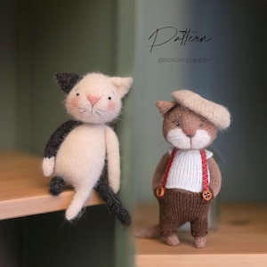 Può includere: Due bambole a forma di gatto fatte a mano. Una è bianca con dettagli neri, l'altra è marrone, con un basco e una salopette. Il testo "Pattern" e l'handle di Instagram "@sosole.puppen" sono visibili.